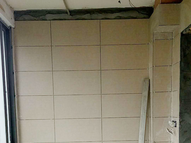 衛(wèi)生間瓷磚鋪貼：基層處理：將凸出墻面的混凝土剔平，對于基體為混凝土表面很光滑的要鑿毛，或用可摻界劑膠的水泥水細砂漿做小拉毛墻，也可以刷界面劑、并澆水濕潤基層。浸磚：面磚鑲貼前，應(yīng)挑選顏色、規(guī)格一致的磚；浸泡磚時，將面磚清掃干凈，放入凈水中浸泡2小時上，取出待表面晾干或擦干凈后方可使用。粘貼面磚：粘貼應(yīng)自下而上進行。抹8㎜厚1：0.1：2.5水泥石灰膏砂漿結(jié)合層，要刮平，隨抹隨自上而下粘貼面磚，要求砂漿飽滿，虧灰時，取下重貼，并隨時用靠尺檢查整度，同時保證縫隙寬度一致。