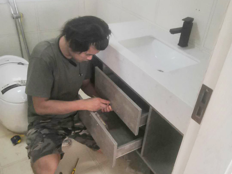 浴室柜及燈具安裝：安裝前，檢查零配件是否齊全。安裝三角閥，確保冷熱進(jìn)水管保持齊平。測量距離，安裝下水管。涂抹膠水要均勻，確保管與管間連接緊密。安裝柜角，看所有角是否在同一水平。裝好后可做適當(dāng)?shù)恼{(diào)整。將浴室柜靠墻放好?？催M(jìn)出水管位置是否得當(dāng)，不合適時需做一定改動。安裝臺盆的龍頭。龍頭最好與浴室柜配套購買，這樣出水角度較為適合。用螺母固定臺盆龍頭。固定時一只手要扶好龍頭，以免裝好后位置偏離。將裝好龍頭的臺盆放在浴室柜上，調(diào)整位置到最佳為止。連接臺盆的進(jìn)出水管及下水，長度適當(dāng)，位置合理。裝好柜體的把手，并進(jìn)行適