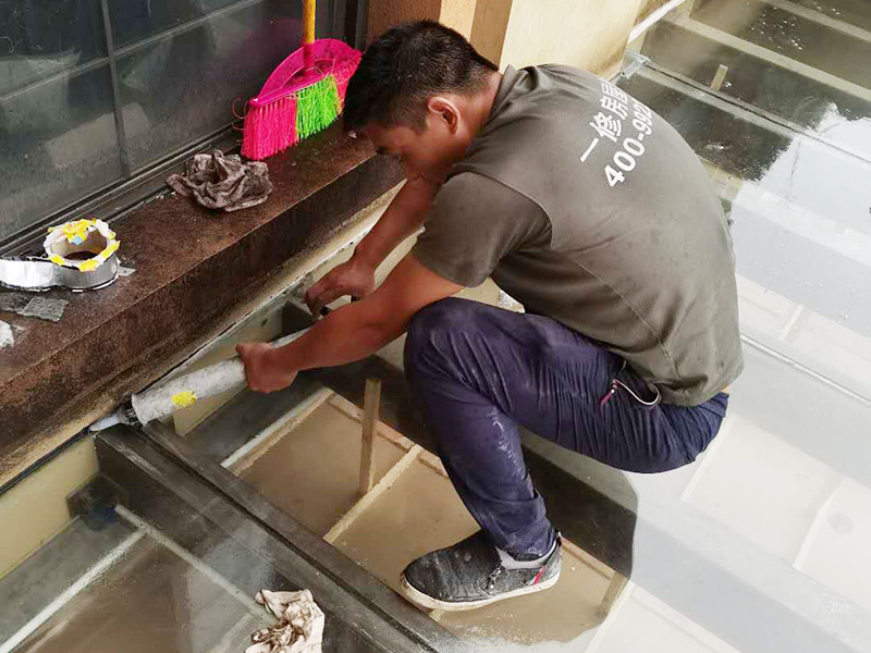 屋頂防水打膠案例：不少建筑新建成就滲漏，老建筑的滲漏現(xiàn)象更嚴重。第一步：把玻璃的邊清理干凈。把玻璃固定到位。在玻璃邊緣3mm處貼美文紙。第二步：用結構膠往縫里填到60％。第三步：用和縫大小的泡抹棒往里壓填充，把膠往玻璃與型材的縫里擠。第四步：填充耐候密封膠，用刮刀來回30度角度刮2遍。缺膠的補上。30分內(nèi)把紙揭掉。