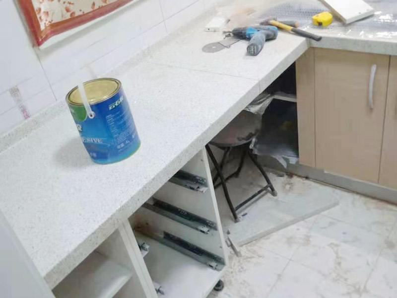櫥柜維修改造：對廚房作防護措施,掛擋布、廚房墻面等做簡單清理,以便準確測量地面水平。 材料進場:櫥柜板材等進場。  安裝地柜 組裝:統(tǒng)一組裝好地柜,搬進廚房,按圖紙順序擺放好位置(倒放),統(tǒng)一安裝地腳。 現(xiàn)場切割:地面上墊上保護物,割口根據(jù)實物的大小從反面進行操作,保持正面不崩。 安裝順序：如有轉(zhuǎn)角柜應(yīng)先安轉(zhuǎn)角柜，沒有轉(zhuǎn)角柜先從靠墻的柜往外安裝。 水平調(diào)整：通過地柜的調(diào)節(jié)腿調(diào)節(jié)地柜水平度，誤差保持正負1mm。